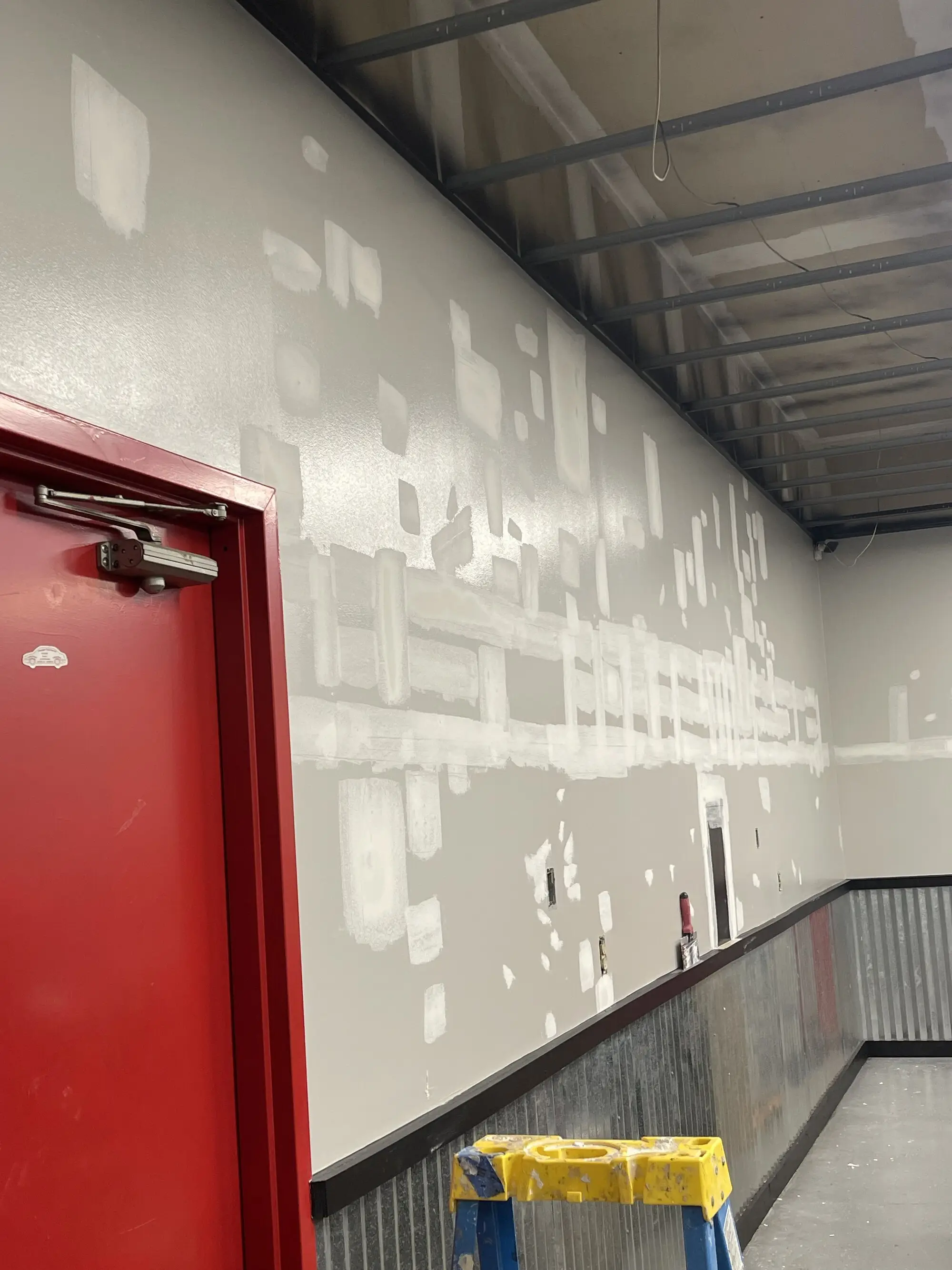 Long commercial wall blocked out from dark to light, the old colour still ghosting through