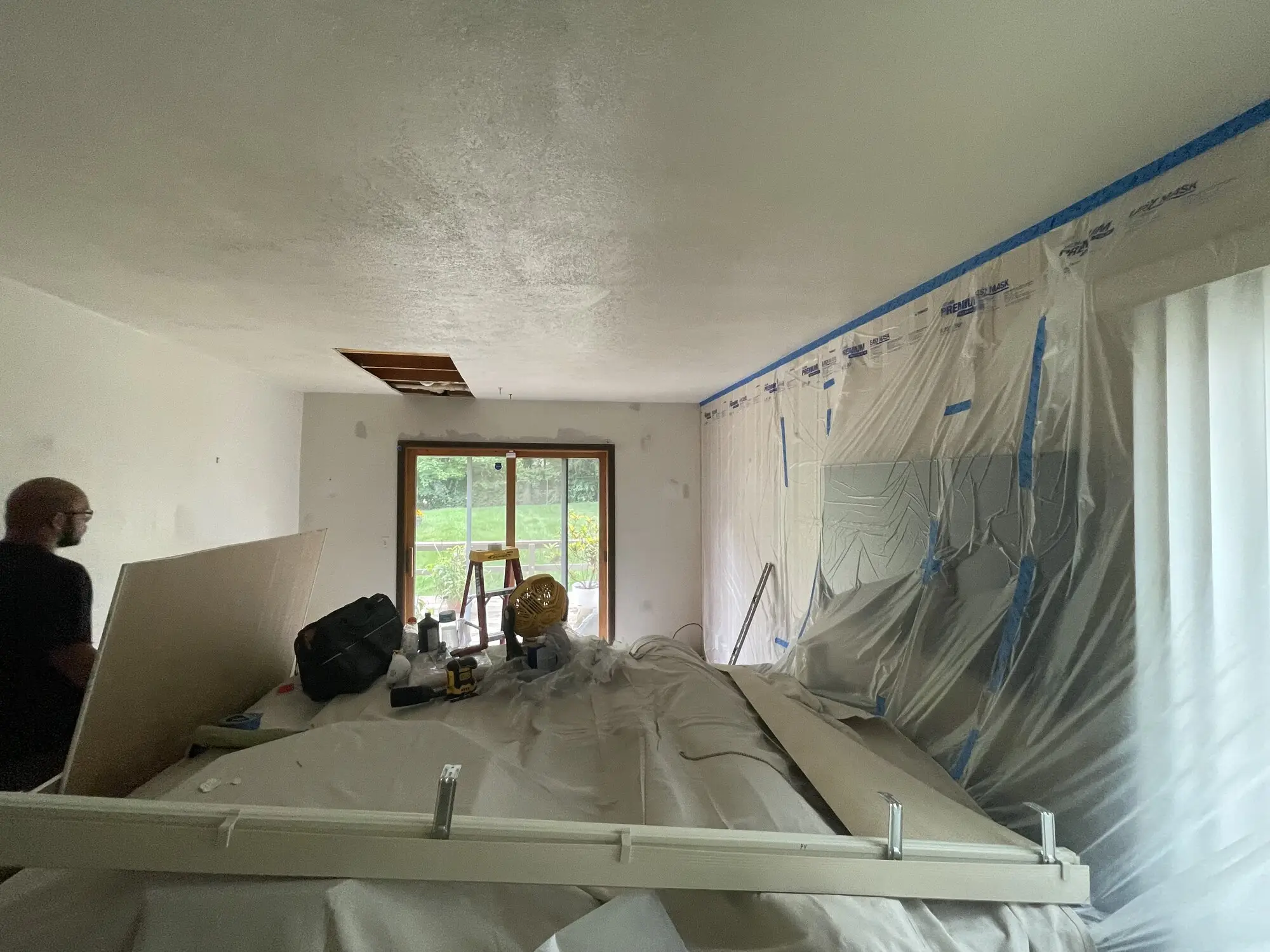 Room fully masked in plastic sheeting and drop cloths before work starts